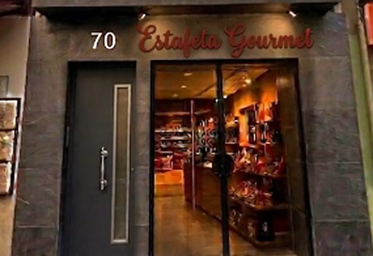 Fachada de la tienda Estafeta Gourmet en la calle Estafeta, 70, con el escaparate iluminado